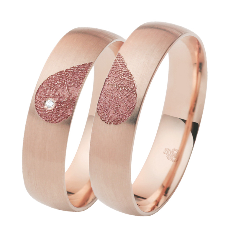 Aufnahme von Eheringen aus Roségold mit Diamanten und Herzmuster mit Fingerabdruck