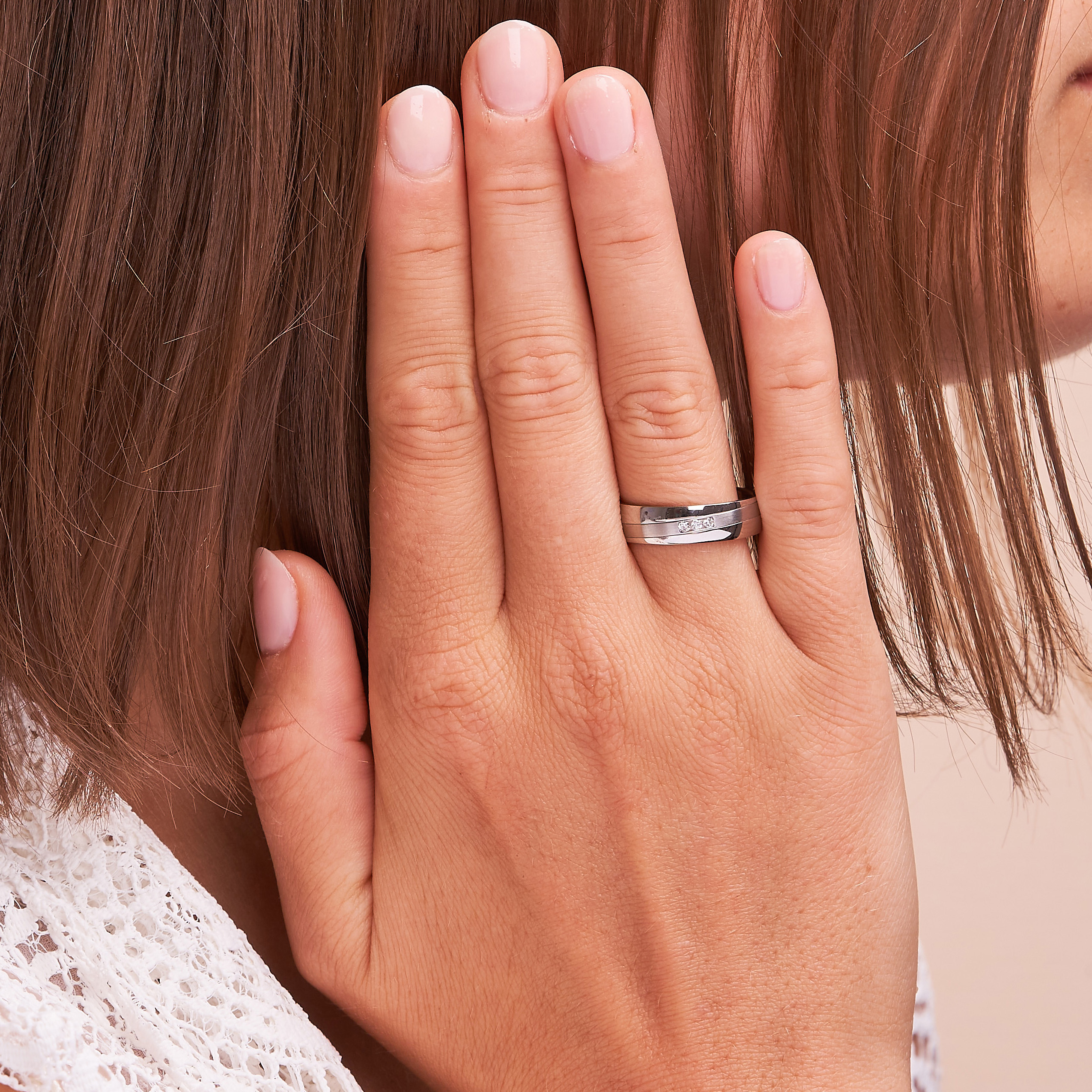 Aufnahme von Trauringen aus Stahl mit Streifen und 3 Diamanten in Vertiefung auf Hand