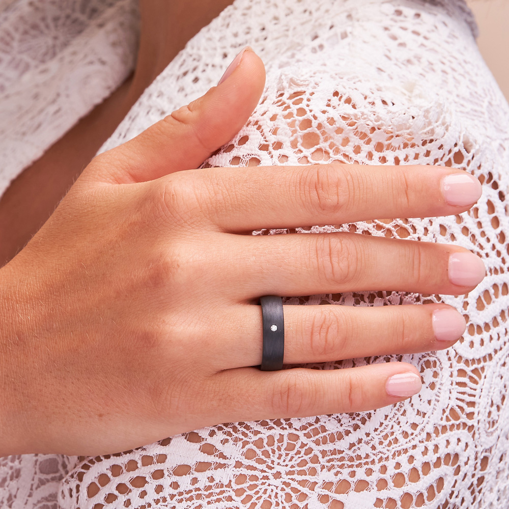 Aufnahme von schwarzem Carbonring auf Hand mit Diamanten in 6 mm auf Hand