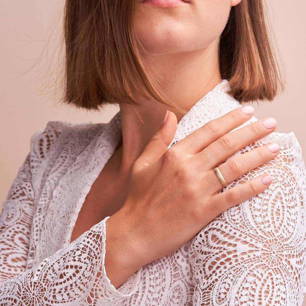 Aufnahme von Gelbgold Eheringen mit Diamanten in 4 mm und sandmatter Oberfläche auf Hand