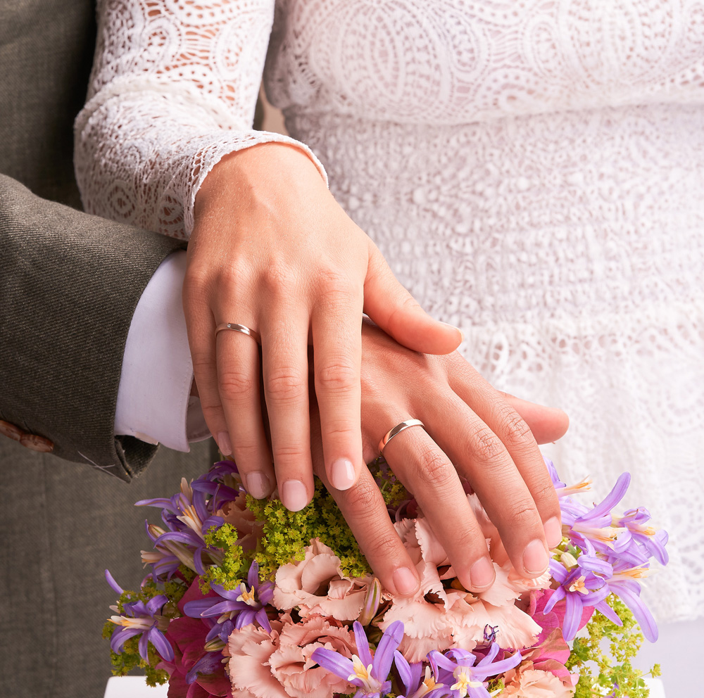 Aufnahme der Eheringe in Roségold mit glänzender und sandmattierter Flächen mit Diamanten auf Hand