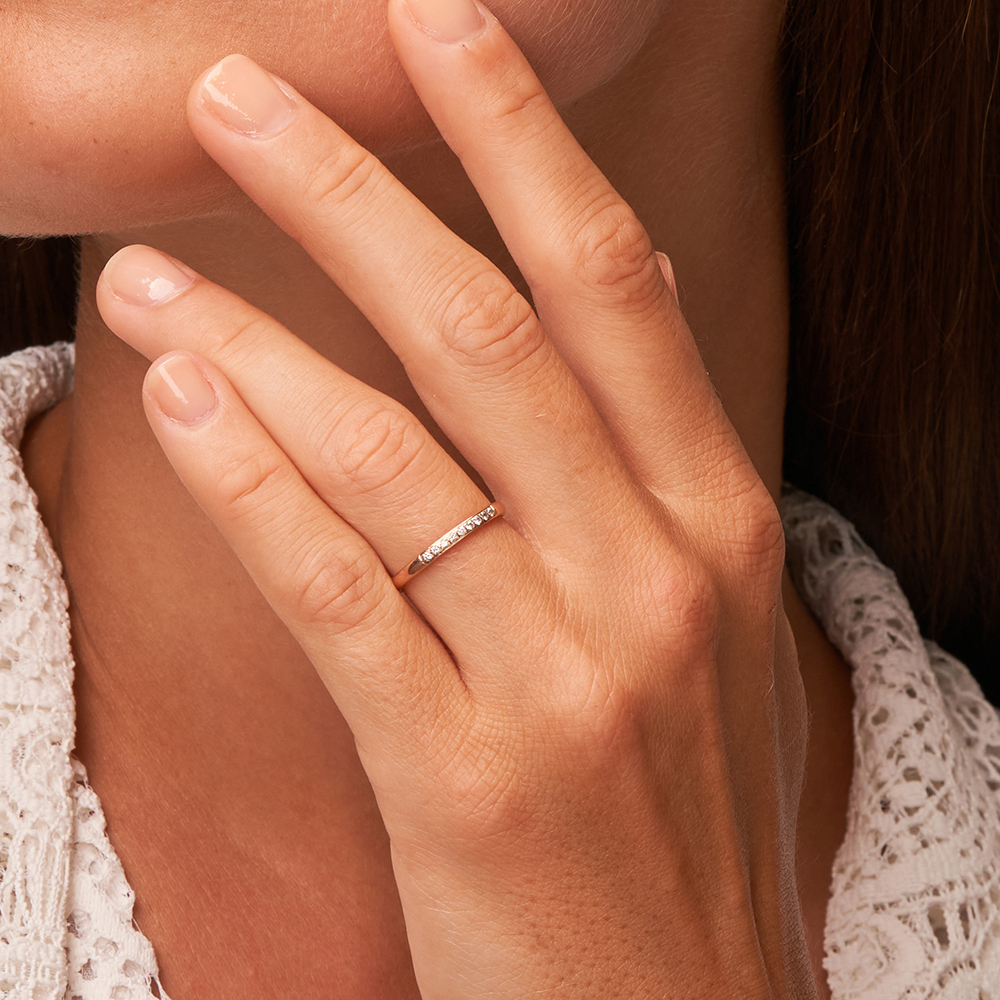 Polierter schmaler Roségold Memoire Ring mit 9 Diamanten auf Hand in Nahaufnahme