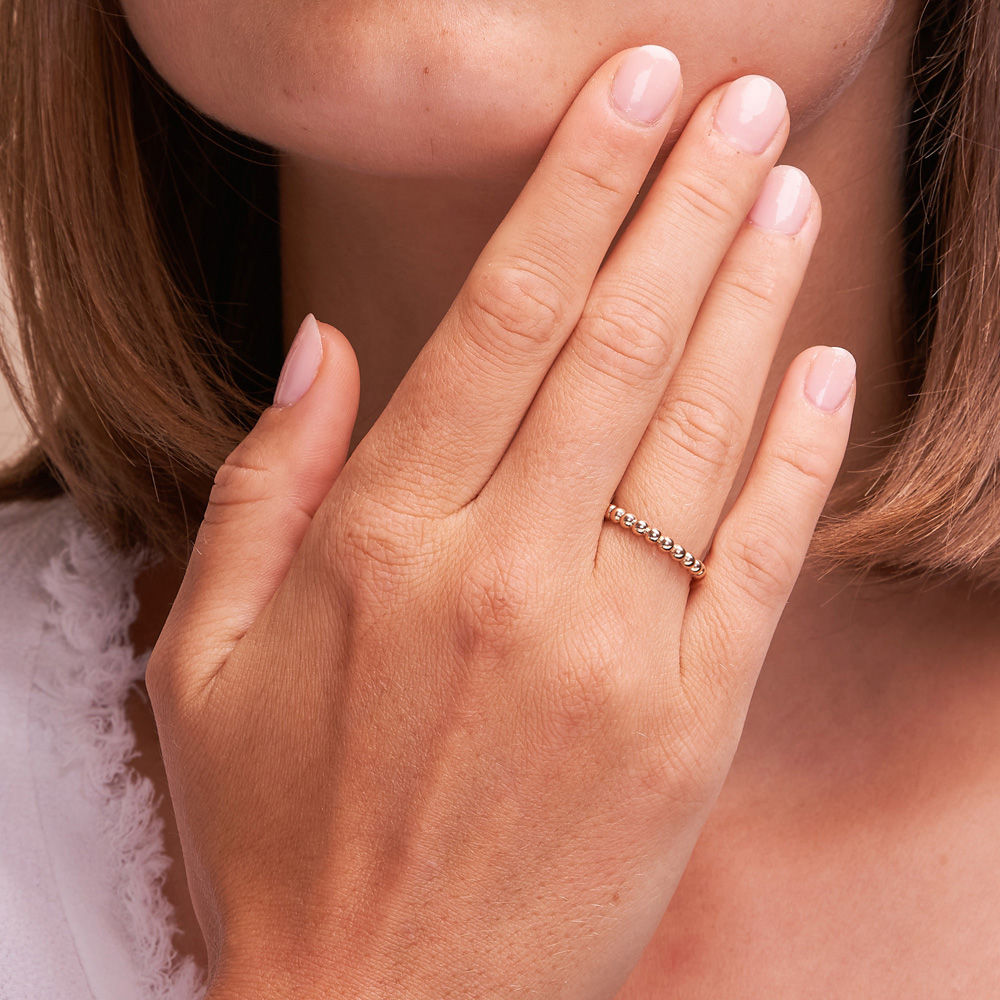 Polierter Roségold Beisteckring mit Kugelmuster auf Hand