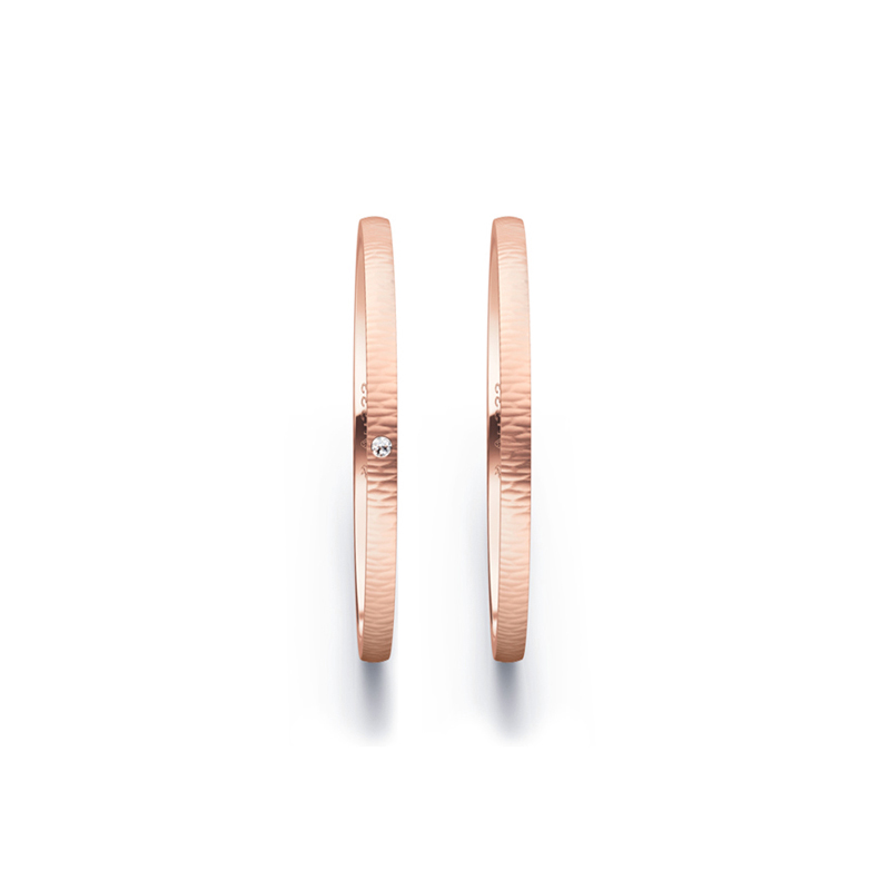 Aufnahme von schmalen Eheringen aus Rosegold in 1,5 mm Breite mit Relief und Diamant