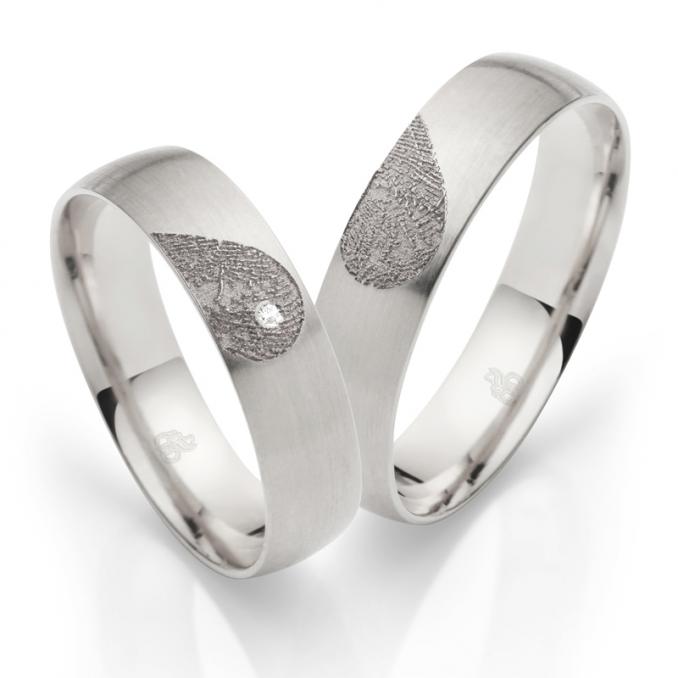 Aufnahme von Eheringen aus Weissgold mit Diamanten und Herzmuster mit Fingerabdruck