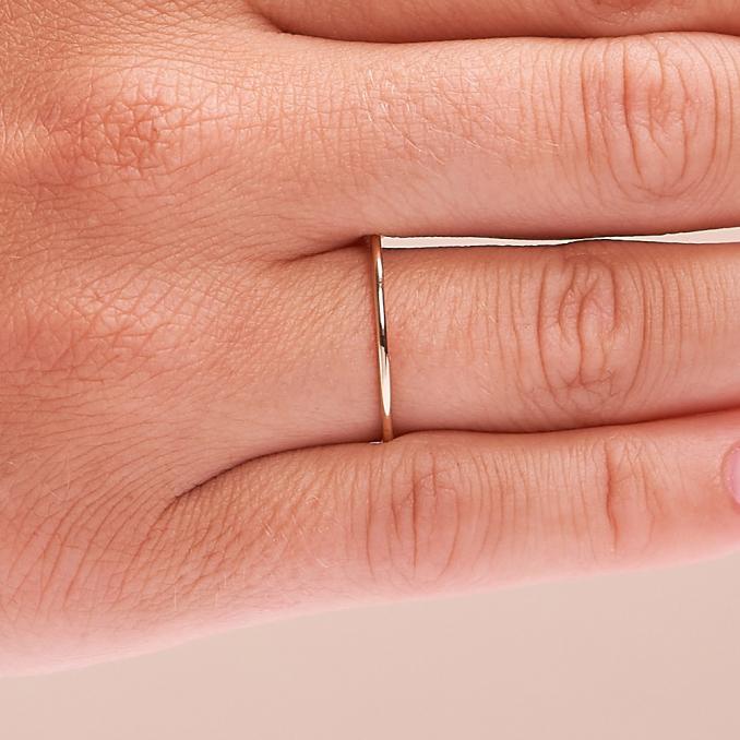 Aufnahme von superschmalem Schmuckring aus Gelbgold 585 mit poliertef Fläche auf Hand