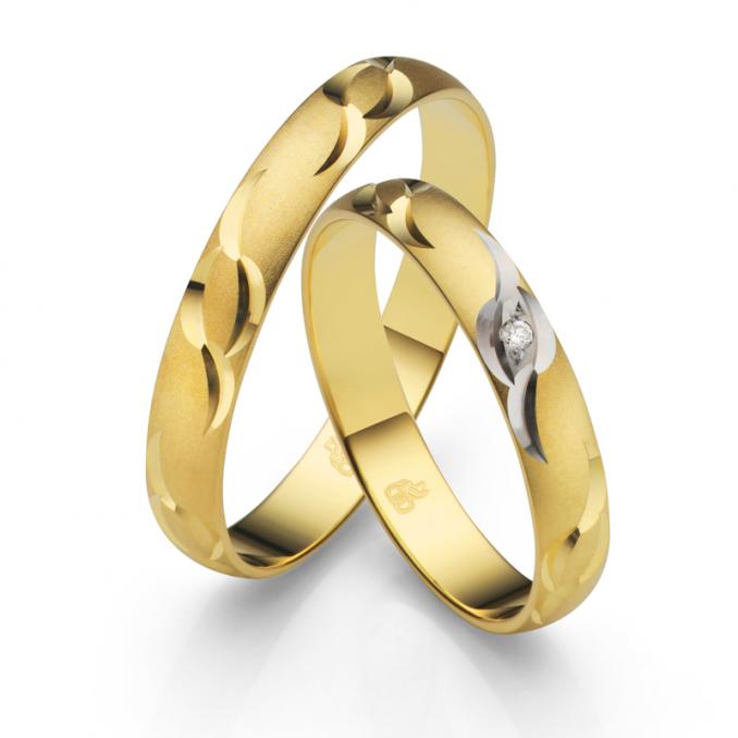 Aufnahme der Trauringe aus Gelbgold sandmattiert mit Kerbenmuster und Diamanten