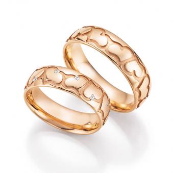 Aufnahme der Eheringe aus Roségold mit Herzenmuster und 12 Diamanten