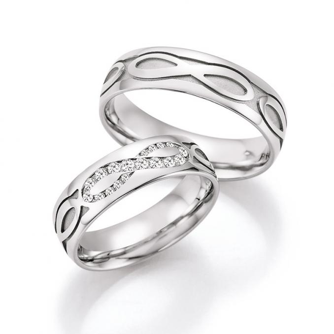 Aufnahme der Eheringe aus Weißgold mit Unendlichkeit-Zeichen-Muster und 18 Diamanten
