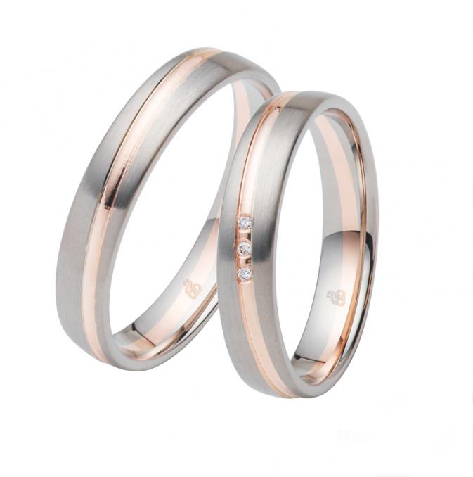 Aufnahme von Trauringen aus Roségold und Weissgold mit Längsmattierung und drei Diamanten
