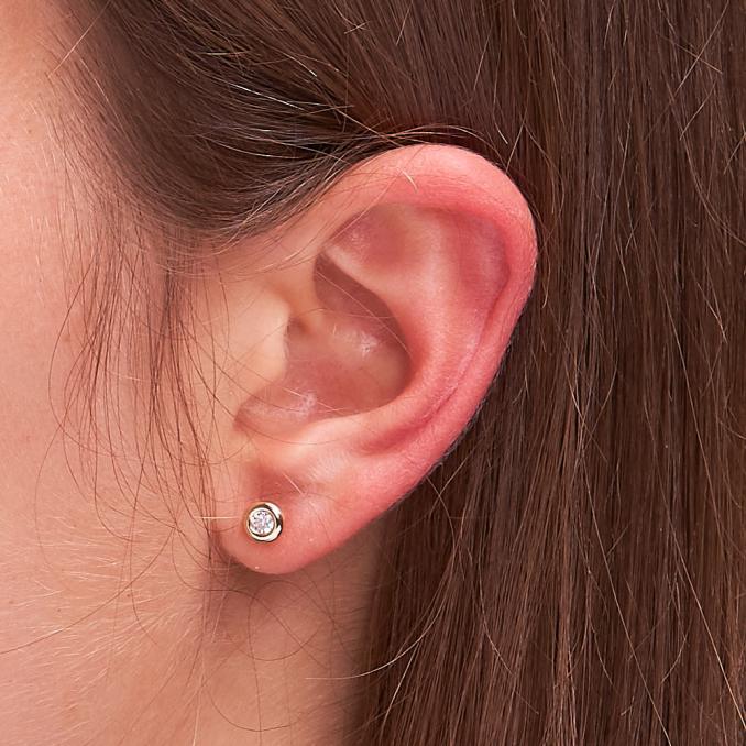 Aufnahme von Gelbgold Ohrsteckern mit Zirkonia am Ohrläppchen