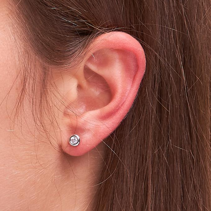 Aufnahme von Weißgold Ohrsteckern mit Zirkonia am Ohrläppchen