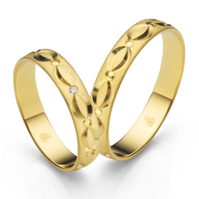 Aufnahme der Trauringe aus Gelbgold quermattiert mit verspieltem Muster und Diamanten