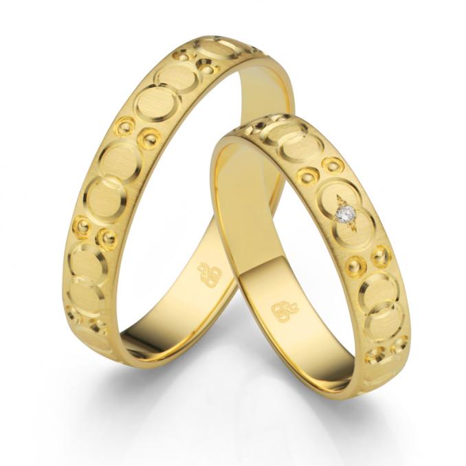 Aufnahme der Trauringe aus Gelbgold mattiert mit Kreisenmuster und Diamanten