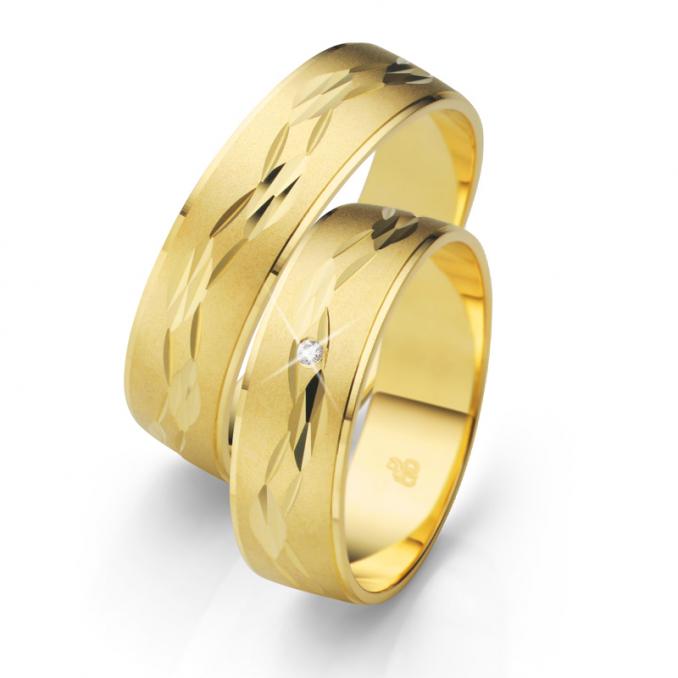Aufnahme der Eheringe aus Gelbgold mit sandmattierter Fläche und Kerbenmuster und Diamanten
