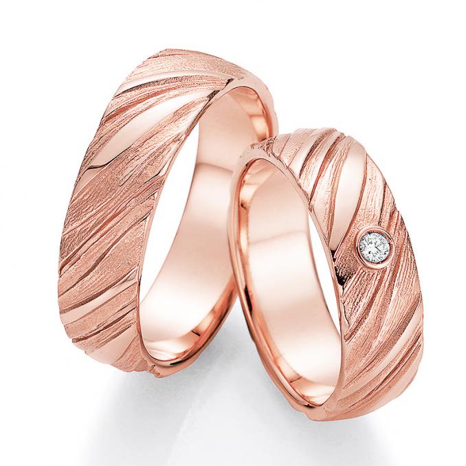 Aufnahme der Roségold Eheringe mit Oberfläche in Holzoptik und Diamanten
