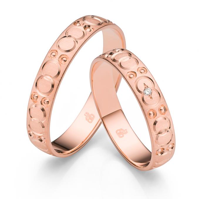 Aufnahme der Trauringe aus Roségold quermattiert mit Kreisenmuster und Diamanten