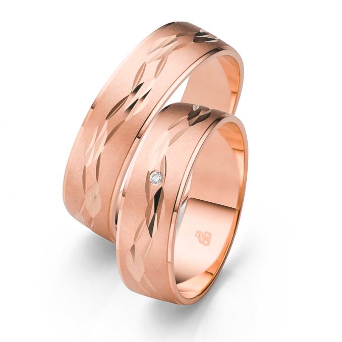 Aufnahme der Trauringe aus Roségold mit Ornament und Sandmattierung und Diamanten