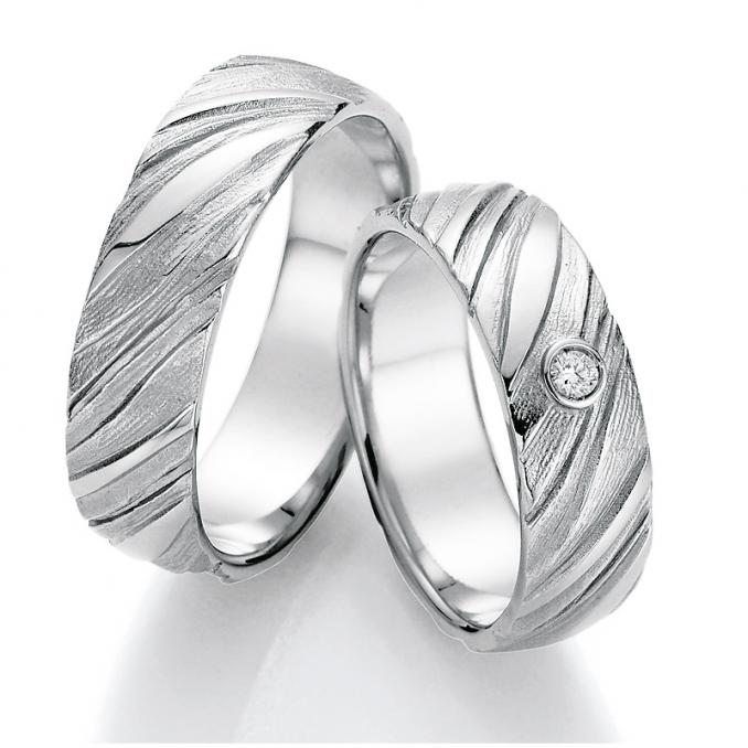 Aufnahme der Eheringe in Silber mit Oberfläche in Holzoptik und Diamanten