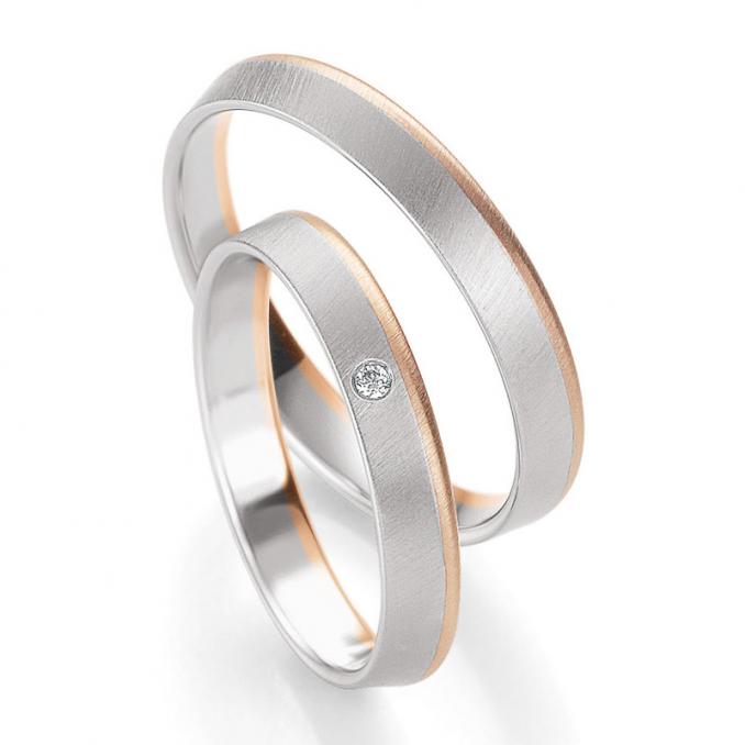 Aufnahme der Trauringe aus mattiertem Weißgold mit Rand aus Roségold und Diamant
