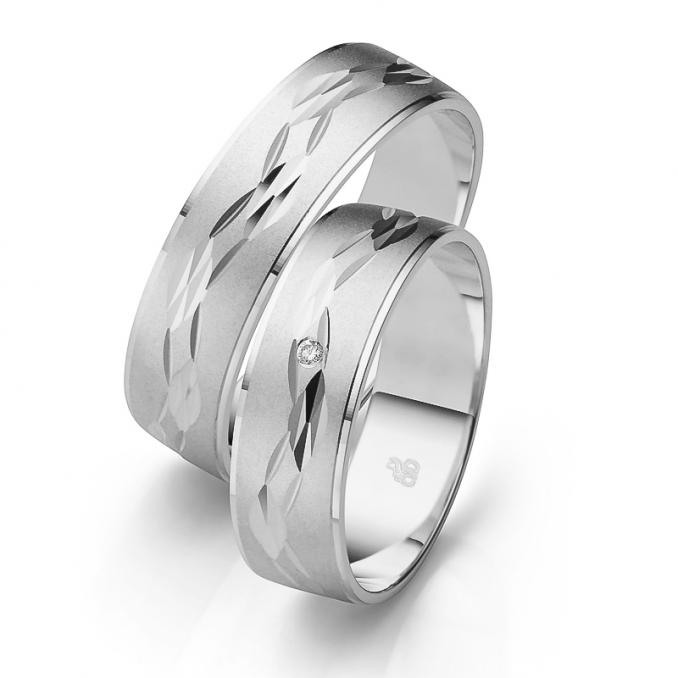Aufnahme der Eheringe aus Weißgold mit Kerben-Dekor sandmattiert mit Diamanten
