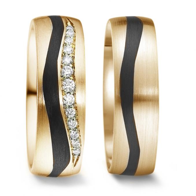 Aufnahme der Trauringe aus Gelbgold mit Welleneinlage aus Carbon mit Diamanten