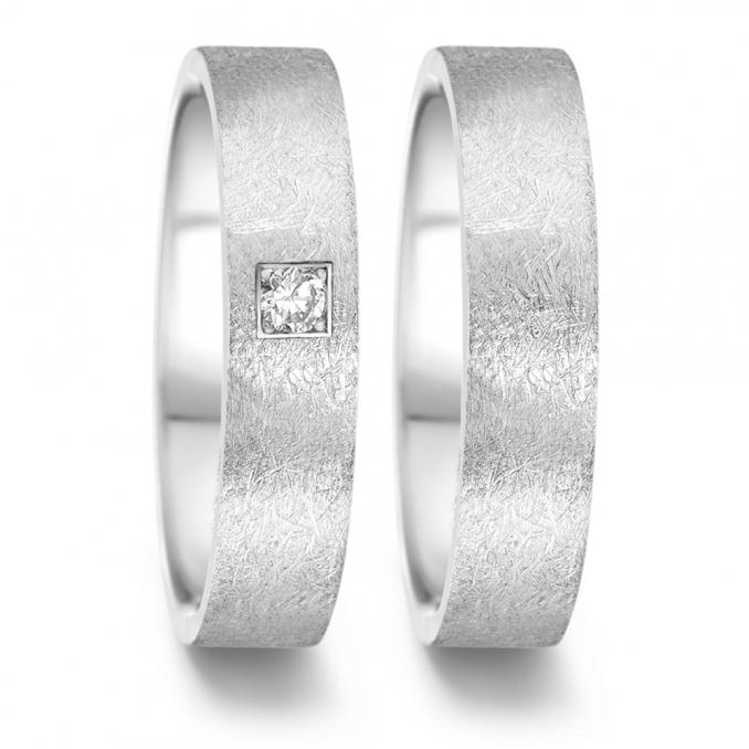 Aufnahme von Eheringen aus Edelstahl mit eismattem Design und Diamanten in Pavee-Fassung