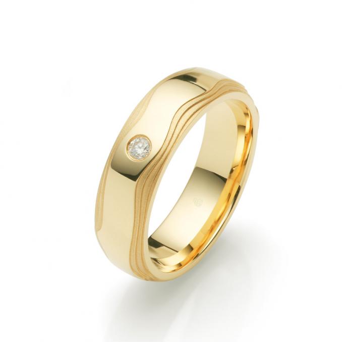 Aufnahme der Gelbgold Trauringe mit welligen Rändern in Wüsten-Design und Diamanten