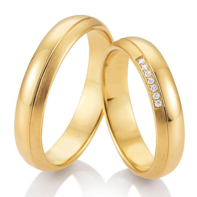 Frontale Aufnahme von gerundeten Trauringen aus Gelbgold mit 7 Diamanten Polierung und Mattierung