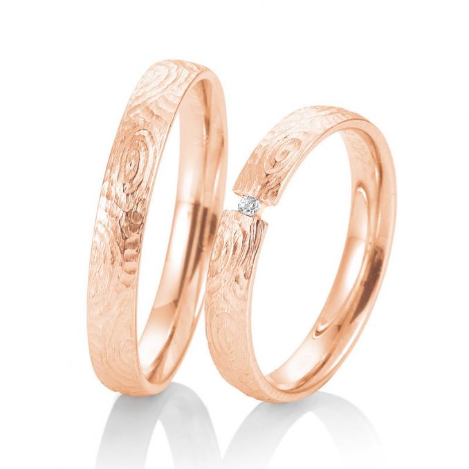 Aufnahme von mit Struktur gestalteten Eheringen aus Roségold mit Diamanten und Muster