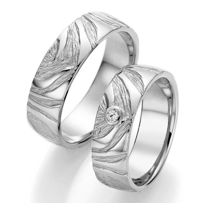 Aufnahme der Eheringe aus Silber mit Struktur und Diamanten