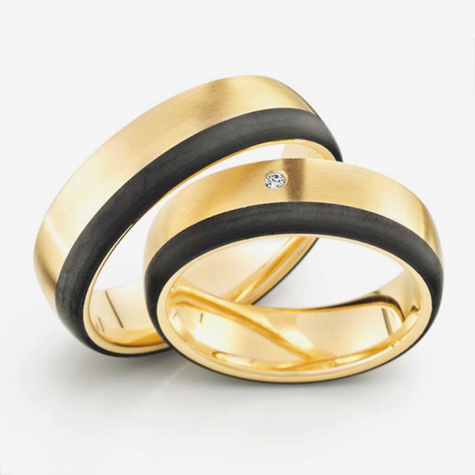 Aufnahme der Trauringe aus Carbon und Gelbgold mit Maserung und Diamanten