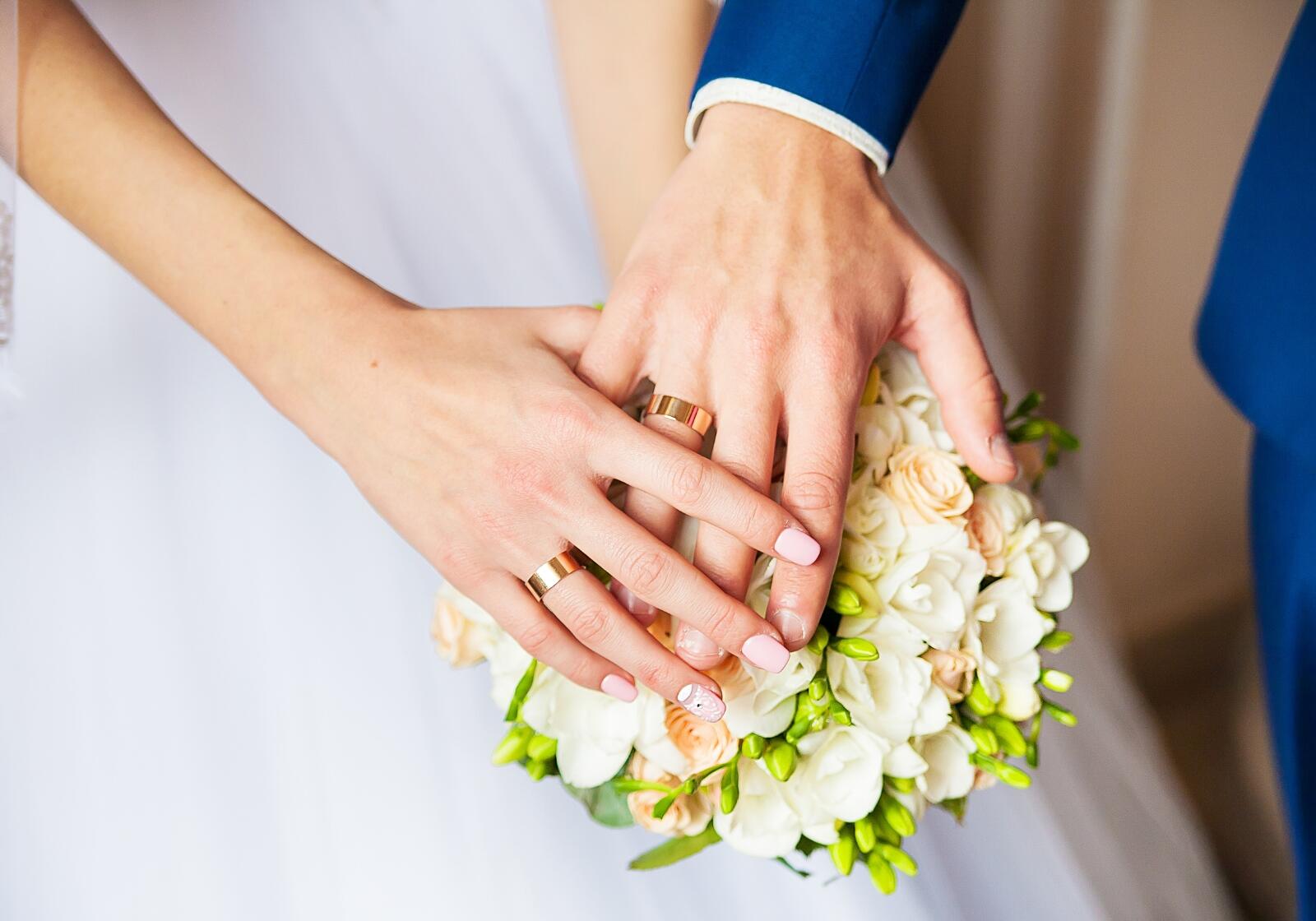 Brautpaar hält sich an den Händen