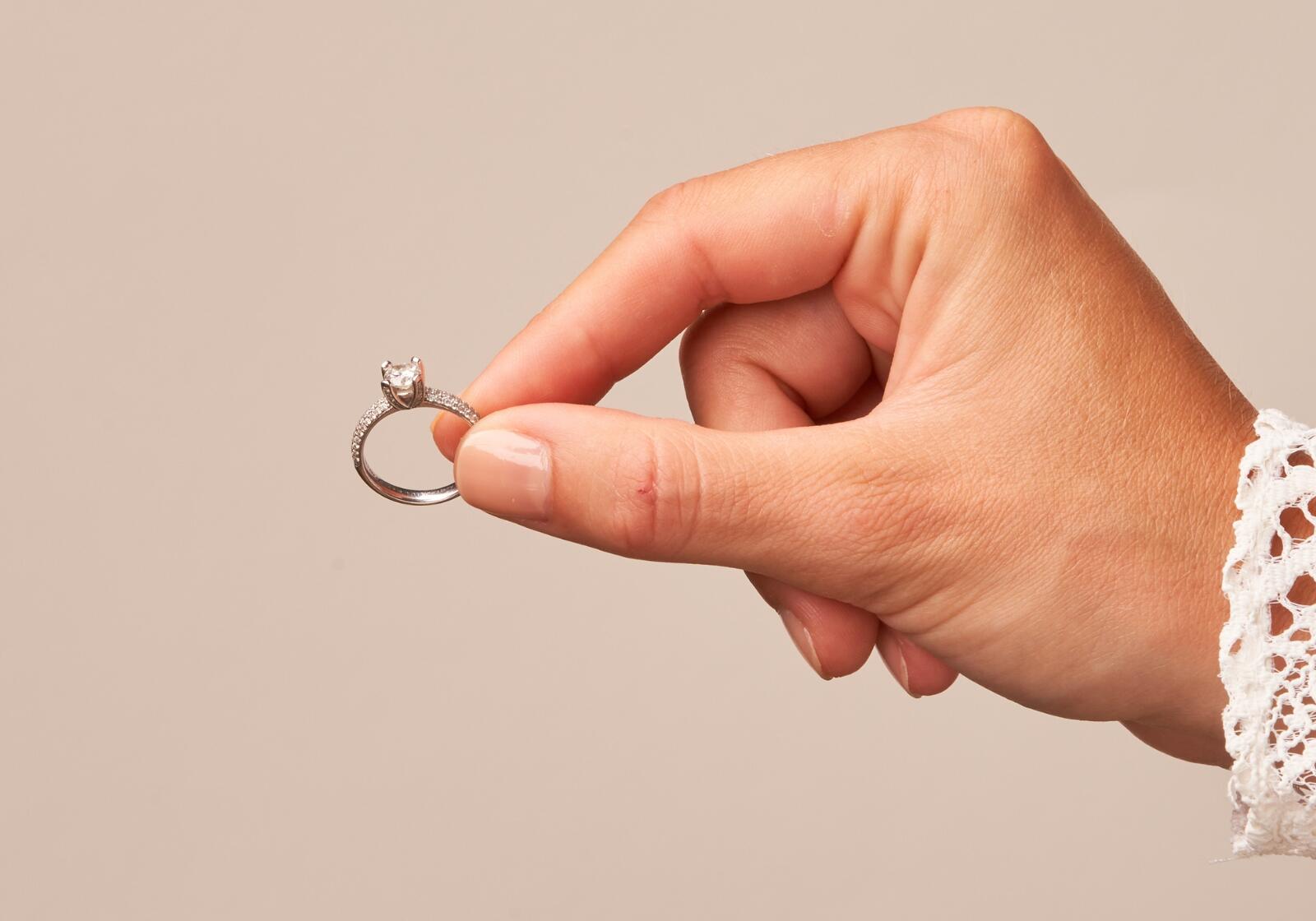 Hand hält Verlobungsring