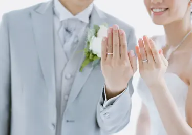 Brautpaar hält Hände mit Ringen in die Kamera