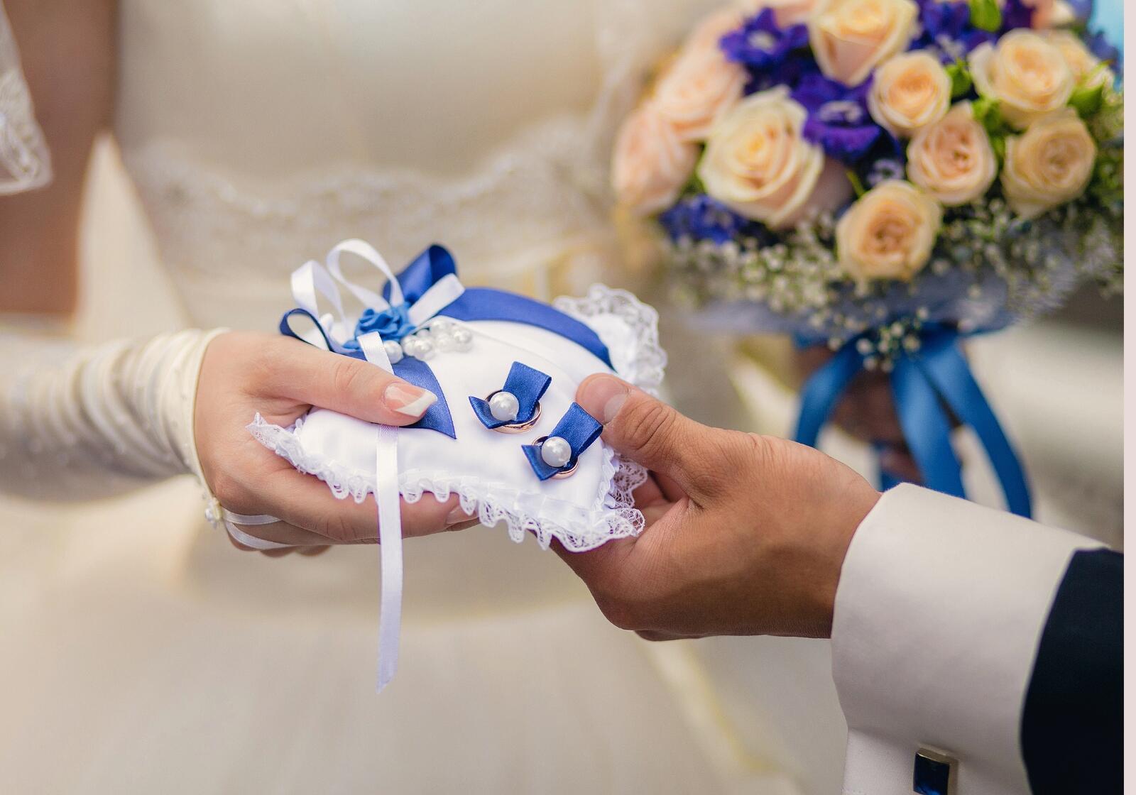 Brautpaar hält Kissen mit Eheringen