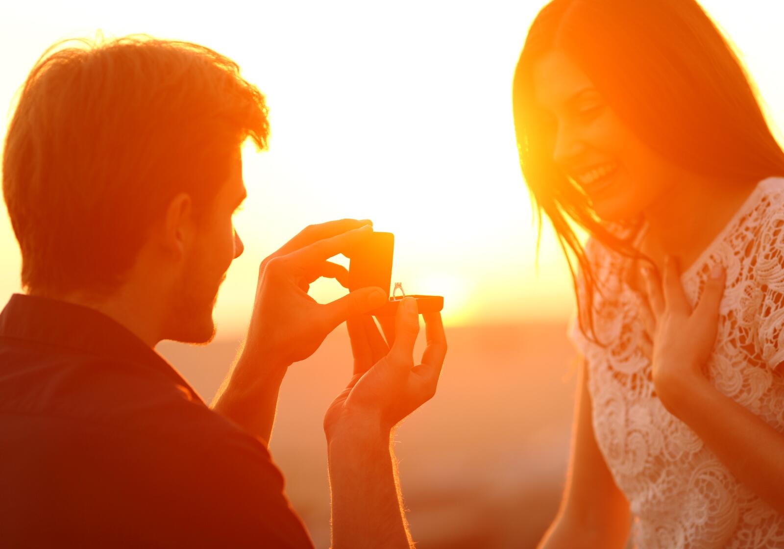 Hochzeitsantrag mit Ring am Strand im Sonnenuntergang