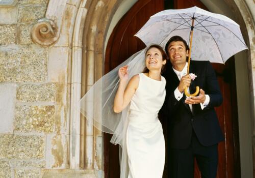 Brautpaar unter Regenschirm