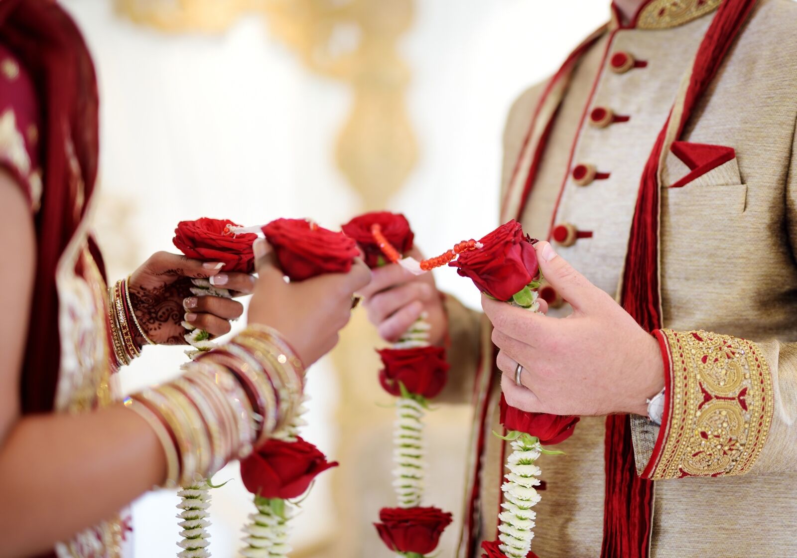 Braut und Bräutigam halten Kette aus Rosen