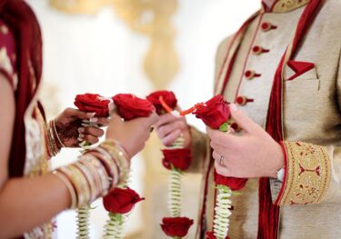 Braut und Bräutigam halten Kette aus Rosen