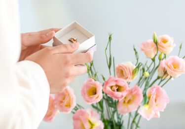 Blumen und Hände mit Ehering Schachtel