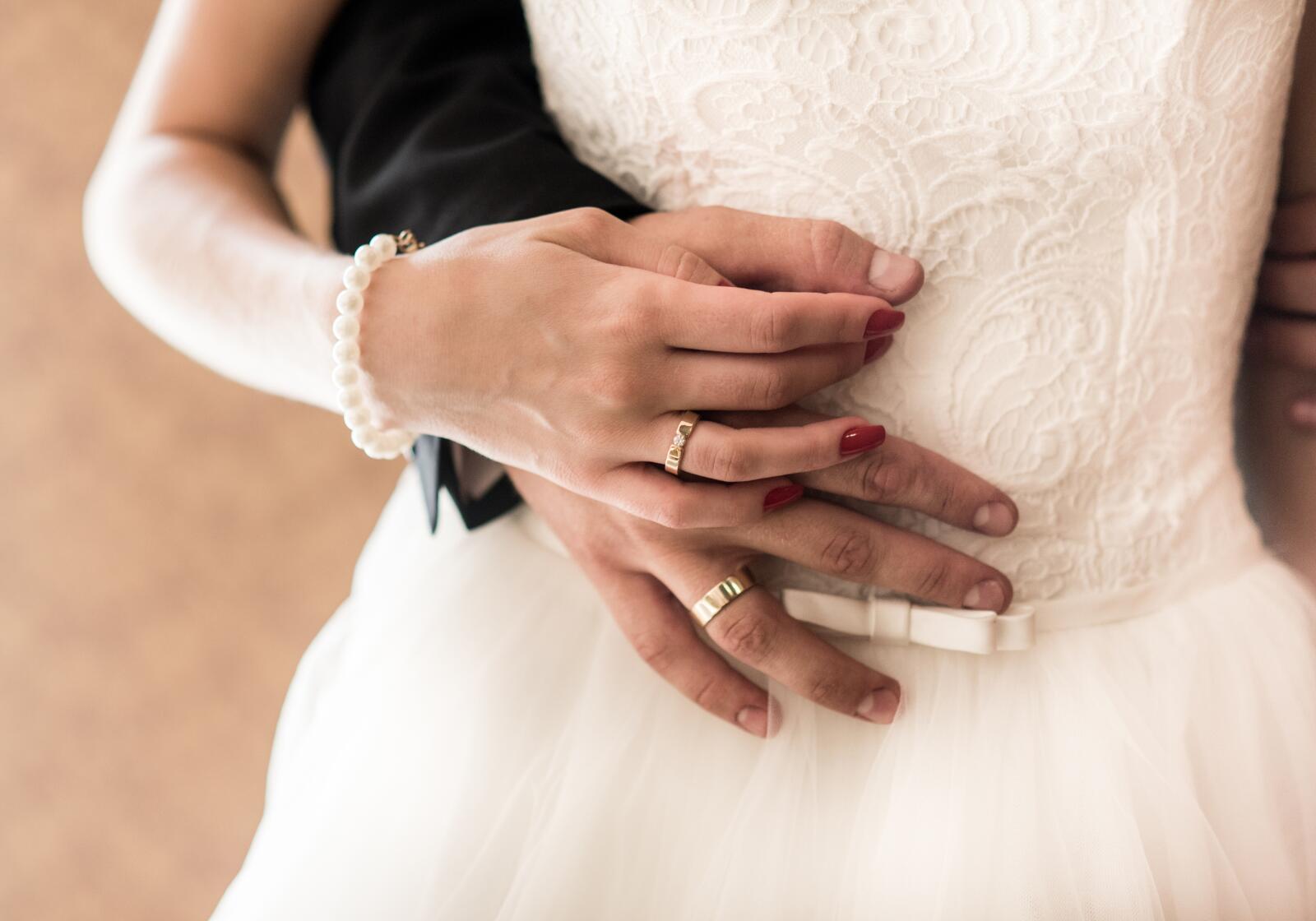 Brautpaar mit Eheringen hält sich an den Händen