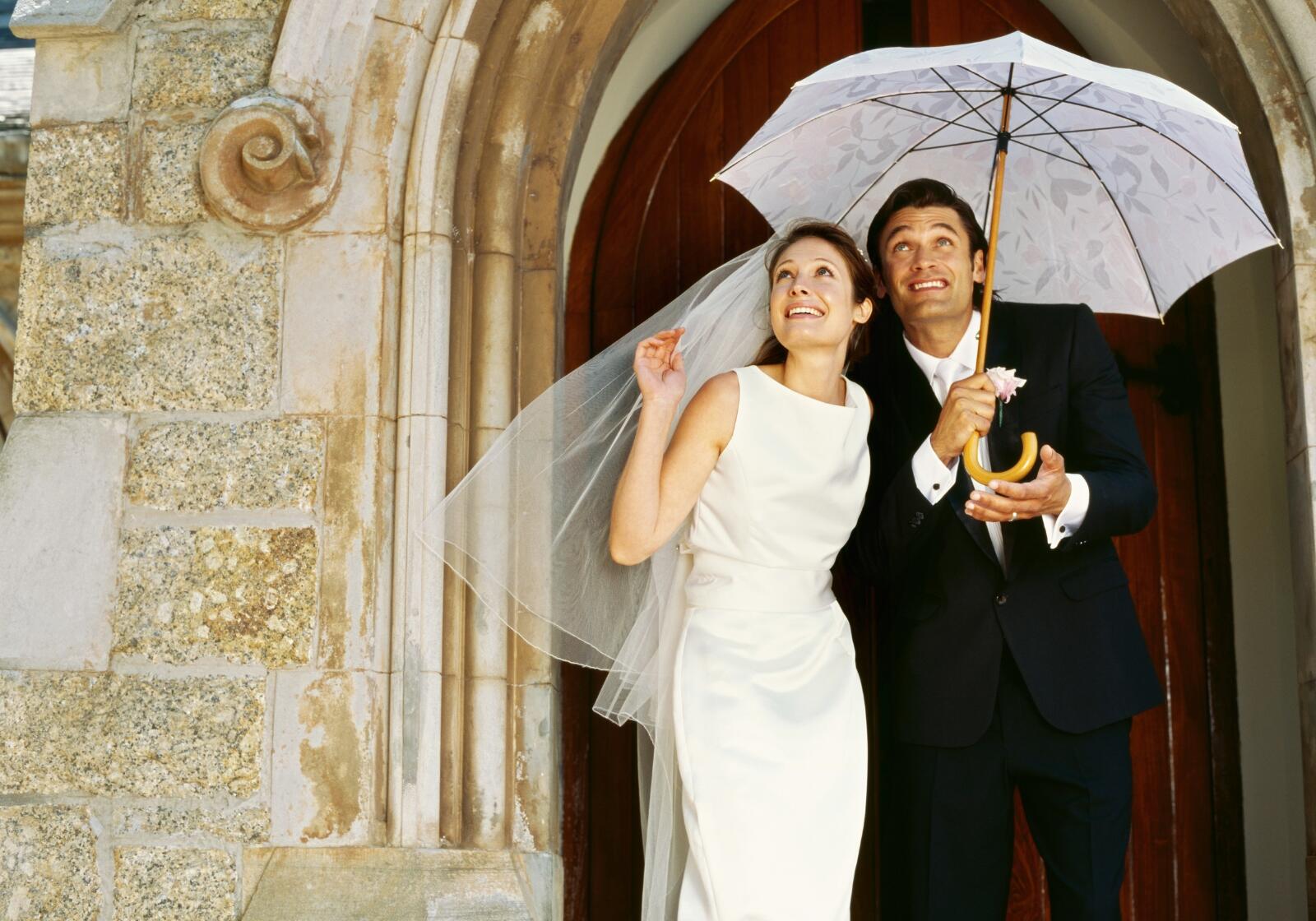 Brautpaar unter Regenschirm